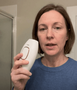 Customer holding Lumimor IPL in bathroom