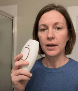 Customer holding Lumimor IPL in bathroom